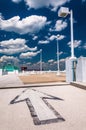 Arrow and street lamp under a partly cloudy sky, on top of a par Royalty Free Stock Photo