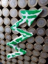 arrow up formed with plasticine in green and white and stacked coins of mexican pesos