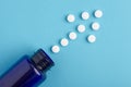 Arrow of white tablets spilling out of package, Close up pills spilling out of pill bottle on blue background. Medicine, medical Royalty Free Stock Photo