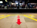 Arrows on the ground point the exit and entry process for the metro as crowds look on