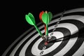 Arrows hitting target on dart board against black Royalty Free Stock Photo