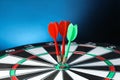 Arrows hitting target on dart board against blue Royalty Free Stock Photo