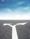 Arrows leading sign on asphalt road and blue sky