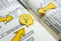 Arrows pointing to light bulb and financial graphs. Business strategy and innovative solutions. Royalty Free Stock Photo
