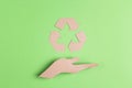 Arrows recycle eco symbol on cardboard hand silhouette on green background Royalty Free Stock Photo