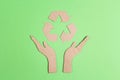 Arrows recycle eco symbol in cardboard hands silhouette on green background Royalty Free Stock Photo