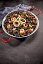 Arroz negro in pan on dark table