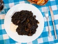 Arroz negro - spanish recipe, black paella with cuttlefish on plate