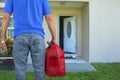 Arsonist man with gasoline can and box of matches preparing to commit arson crime and maliciously burn down a house