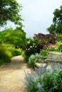 Art bench and flowers in the morning in an English park Royalty Free Stock Photo