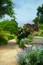 Art bench and flowers in the morning in an English park Royalty Free Stock Photo