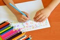 Art class in kindergarten. Child holds a pencil in hand and draws flowers Royalty Free Stock Photo