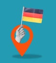 Art collage, hand with a German flag on blue background with a navigation sign Royalty Free Stock Photo