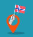 Art collage, hand with a Norwegian flag on blue background with a navigation sign Royalty Free Stock Photo
