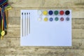 Art concept. Blank sheet of paper, brushes and jars of paint. Wooden background Royalty Free Stock Photo
