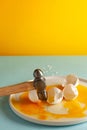 Art concept for Easter or building materials. Broken eggs with a hammer on a white plate on colored backgrounds. Royalty Free Stock Photo