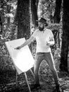 Art concept. Painting in nature. Start new picture. Painter with easel and canvas. Bearded man painter looking for Royalty Free Stock Photo