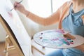 Artist with palette and brush painting at studio Royalty Free Stock Photo