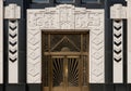 Art Deco entrance featuring a pair of formidable bronze doors with geometric sunburst patterns. Royalty Free Stock Photo