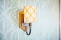 an art deco wall sconce casting patterned shadows