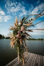 Art Deco wedding arch with pink roses and leaves on a wooden platform for the ceremony Royalty Free Stock Photo