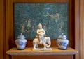 Art display with ceramic vases flanking a statue of buddha sitting on an elephant in a resort on the island of Maui.