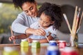 Art education, mother and child painting for an art preschool project with a young mom helping her daughter at home Royalty Free Stock Photo