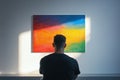 Art enthusiast contemplating vibrant abstract artwork, bathed in sunlight, in a gallery setting Royalty Free Stock Photo