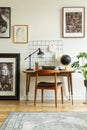 Art gallery in a retro home office interior with a desk and chair. Real photo