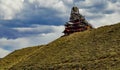 Art House, a unique house made of wood on a hilltop against a backdrop of white clouds. Montana