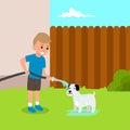 Cute little boy bathes the dog at the backyard