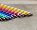A set of colored wooden pens used for coloring and drawing, stacked horizontally next to each other