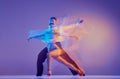 Art in motion. Flexible adorable ballroom dancers in stage attires dancing isolated on purple background in neon mixed Royalty Free Stock Photo