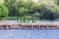 Art object consisting of large green letters with the name of the city of Tver, Russia. The main pier of passenger ships