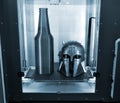Art objects printed on 3D printer are inside 3D printer on desktop.