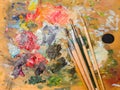 Art paints and brushes lie on the artist`s wooden palette Royalty Free Stock Photo