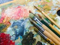 Art paints and brushes lie on the artist`s wooden palette Royalty Free Stock Photo