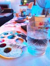 Art palette with paint and a cup of water