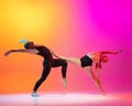 Art performance. Two dancers, stylish sportive couple, male and female models dancing contemporary dance on colorful Royalty Free Stock Photo