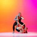 Art performance. Two dancers, stylish sportive couple, male and female models dancing contemporary dance on colorful Royalty Free Stock Photo