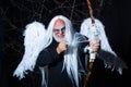 Art photo of a Angelic man. Senior man posing with angel wings. Evil vampire man. Man wizard with fantastic make up on