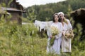 Art Photo of Beautiful Country Girls with Basket of Fresh Bread and Flowers. Posing Together in Countryside Environment Outdoor Royalty Free Stock Photo