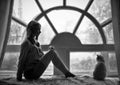 Art photo blond girl and white cat sitting at big old window during the rain. Romantic Black and white photo, loneliness Royalty Free Stock Photo