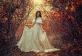 Art photo fantasy woman queen standing in gothic autumn forest, white vintage style dress. Girl princess beauty face Royalty Free Stock Photo