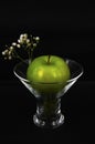 Art photo green apple and white flowers in a glass on a black background Royalty Free Stock Photo