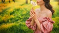 Art photo happy woman holding blowing on dandelion flowers in her hands. Fantasy lady girl princess enjoys nature, fun Royalty Free Stock Photo