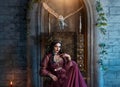 Art photo real people fantasy woman evil elven queen sits on throne, dark magic purple long dress Sexy face witch elf Royalty Free Stock Photo
