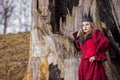 Art Photography Concepts. Mysterious Beautiful Fairy Medieval Princess in Red Dress and Spiky Black Crown in Forest in Early