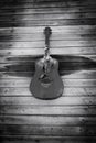 Art photos in black and white. A wooden wall of an old house with an installation in the form of a guitar. Royalty Free Stock Photo