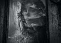 Art portrait of a beautiful young spooky woman, looks through grunge styled window.